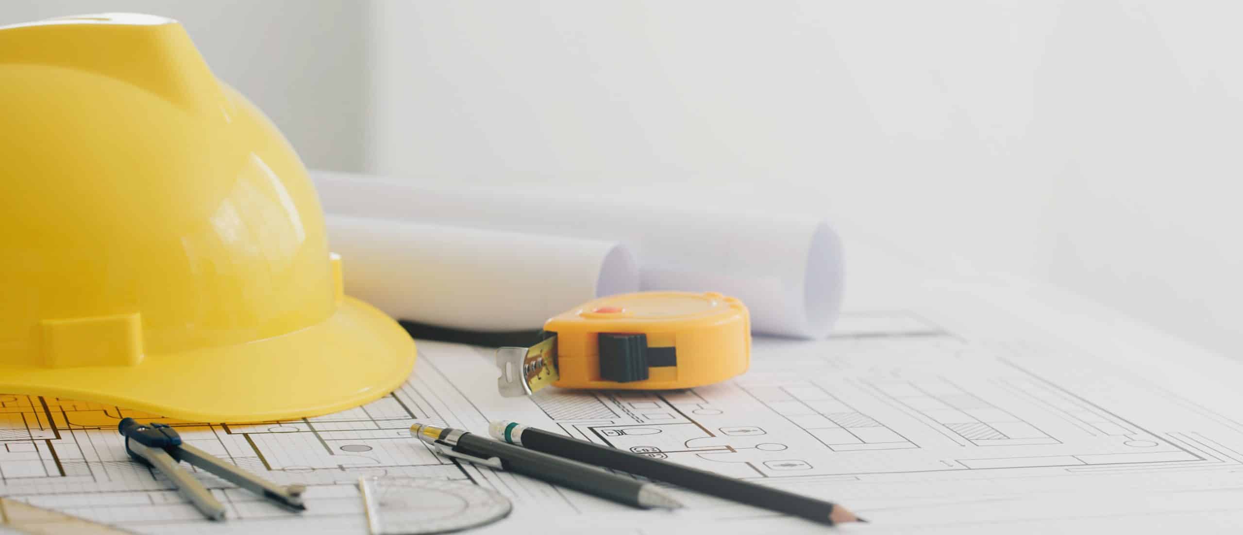Yellow hard safety helmet hat and the blueprint, pen, ruler, pro CIS Payroll Glasgow