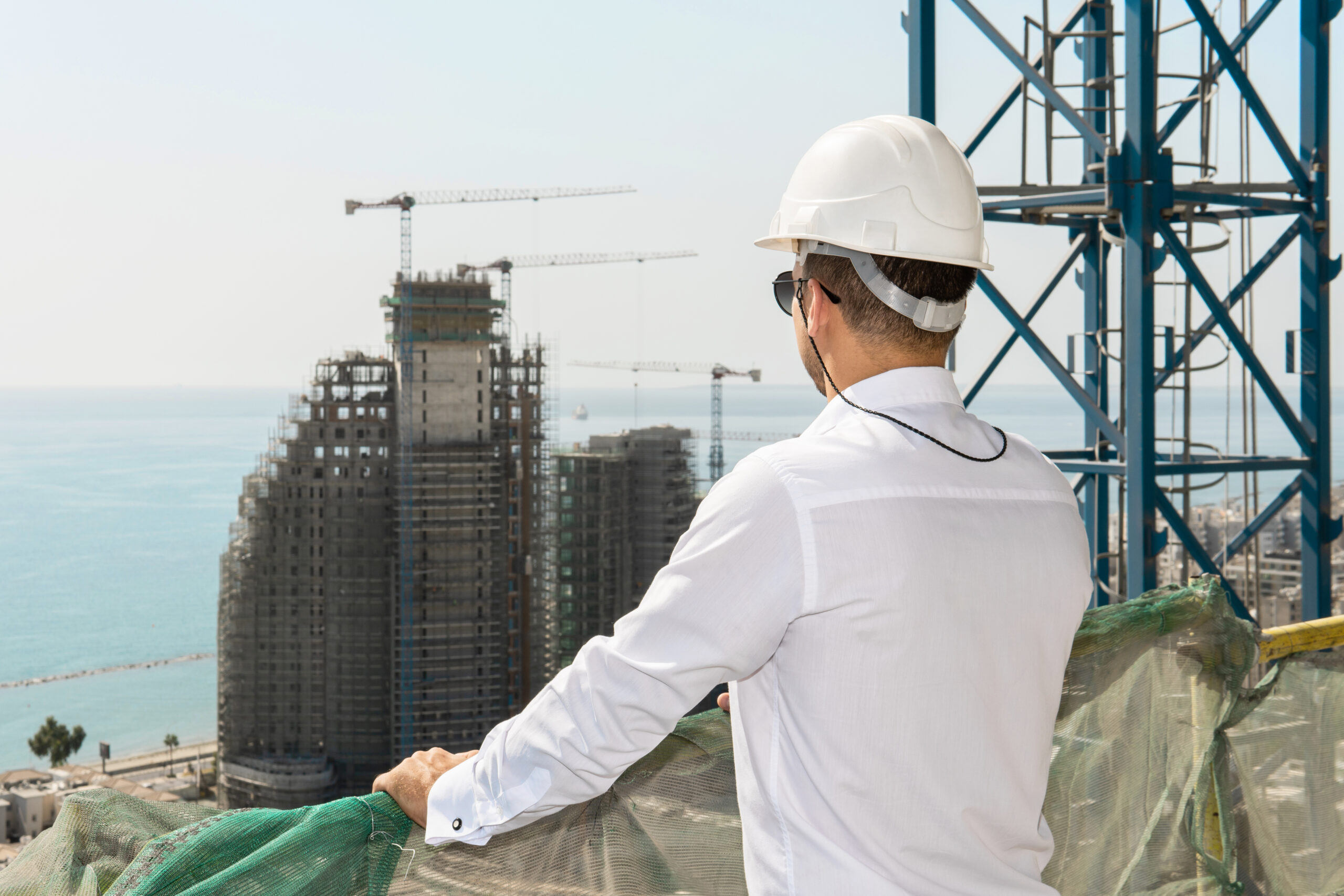 Confident architect or businessman wearing hard hat looking on a construction site