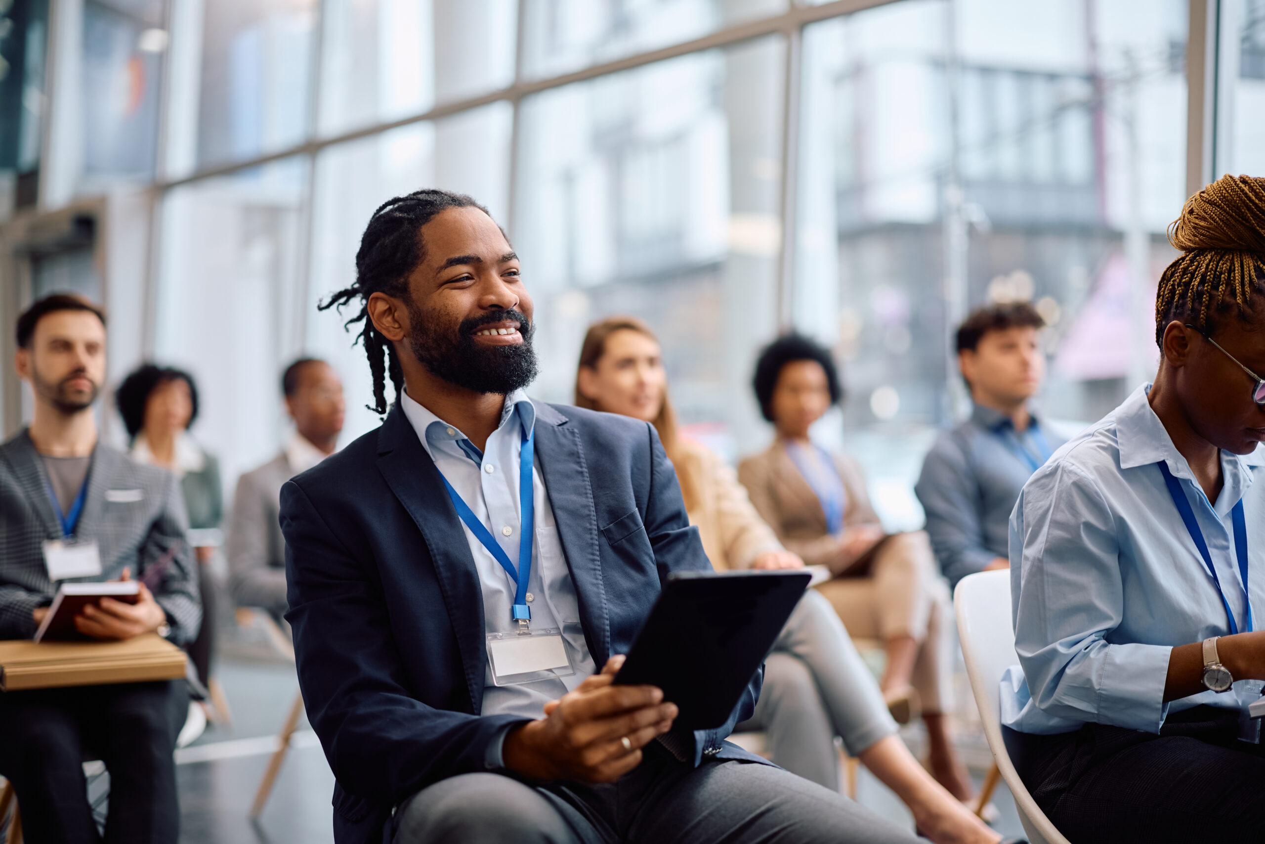 Happy black businessman using touchpad during a seminar in board room.