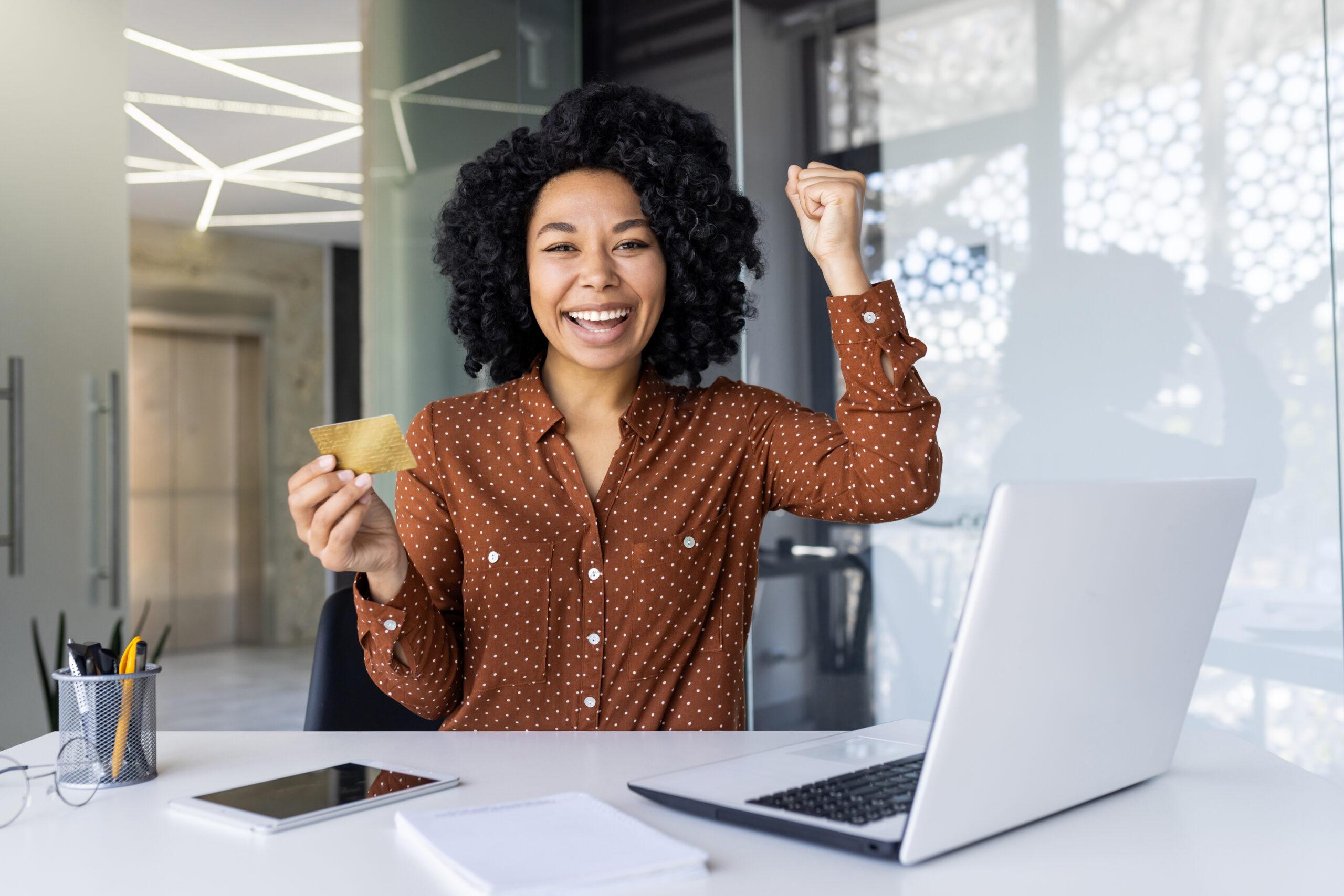 Successful businesswoman celebrating victory in modern office